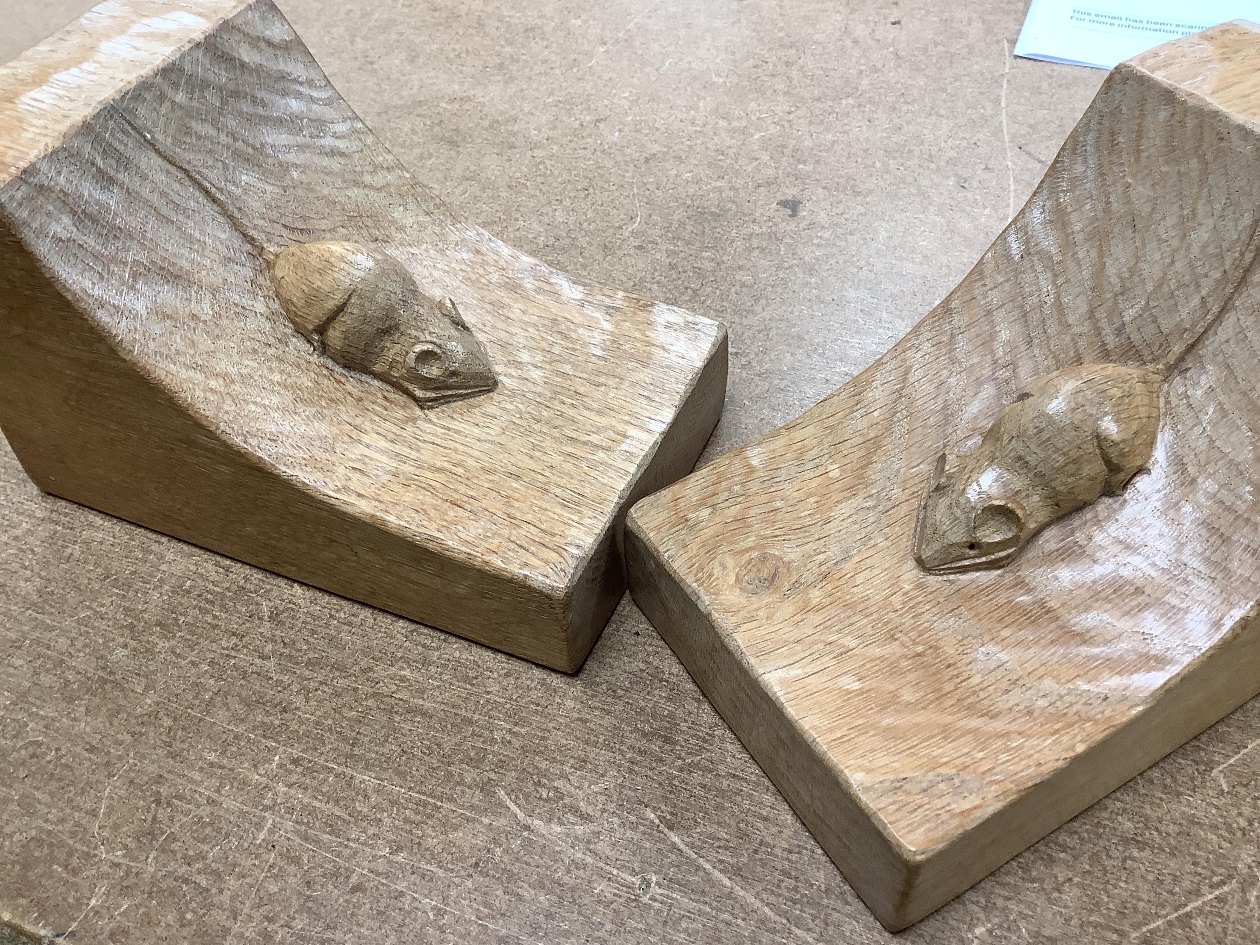 Workshop of Robert ‘’Mouseman’’ Thompson of Kilburn - a pair of English oak single mouse bookends, each with carved mouse trademark, 15cm high. Condition - good.